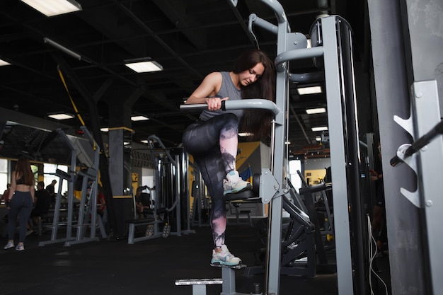 Full length shot of a sportswoman doing stepping buttocks exercise in a gym machine copy space