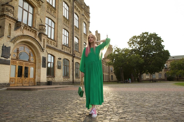 Full length shot of a stunning elegant woman wearing long green dress sightseeing at the ctiy