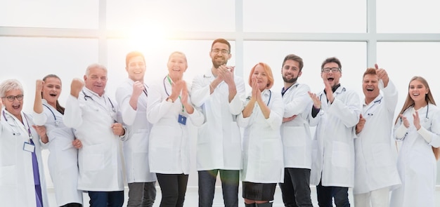 full-length. tight-knit group of medical center doctors applauding together.