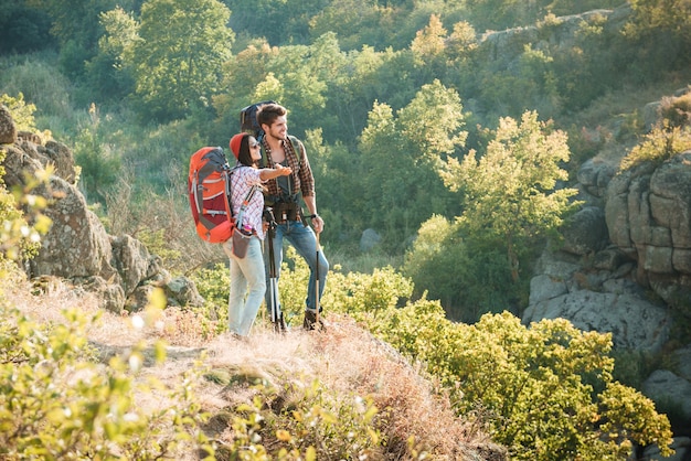 Full length traveling couple near the canyon are looking away