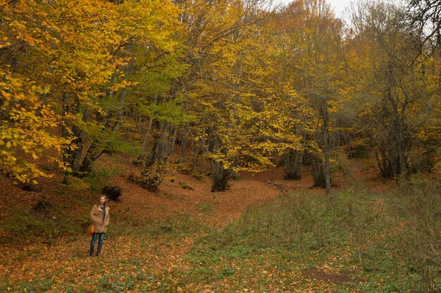 Full length of woman standing in forest during autumn