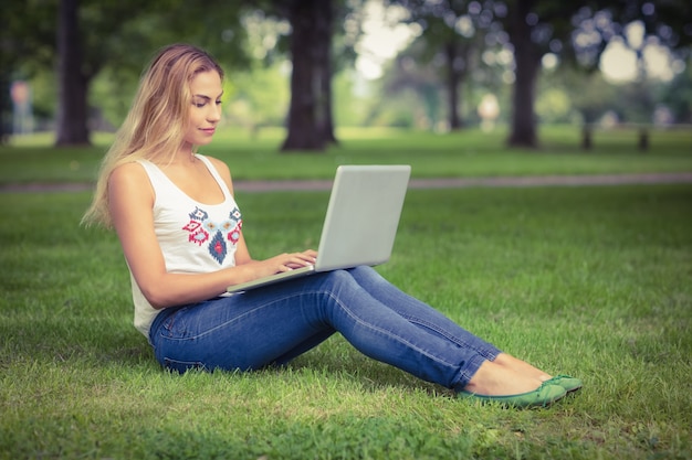 Full length of woman using laptop at park