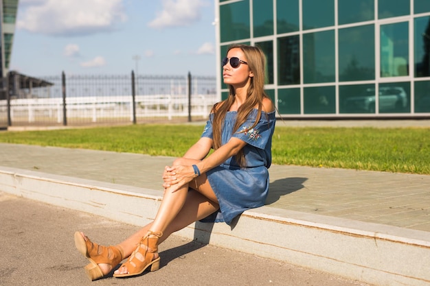 Photo full length of young woman sitting outdoors