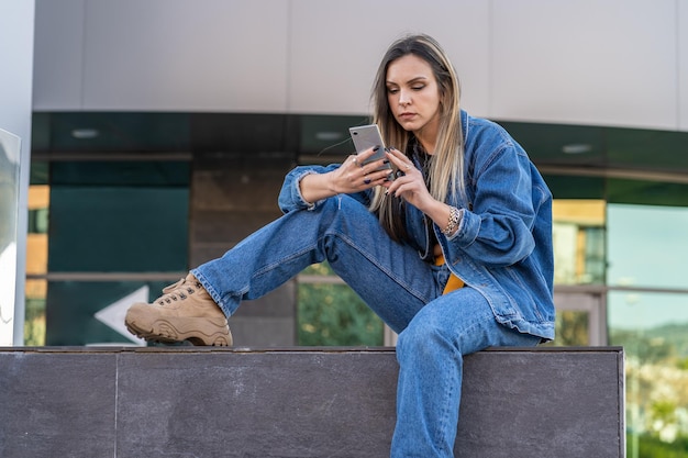 Photo full length of young woman using mobile phone