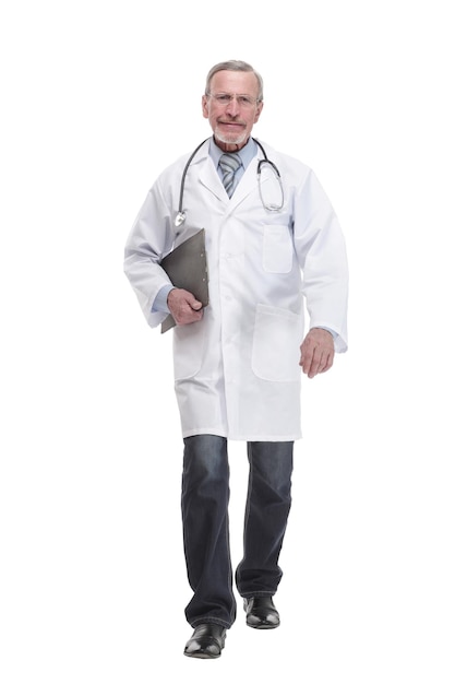 Full lenth of a mature doctor is walking and holding on the clipboard