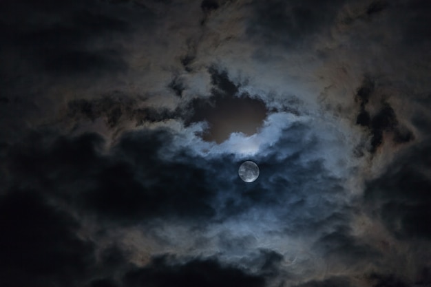 Full moon in the clouds in the night sky