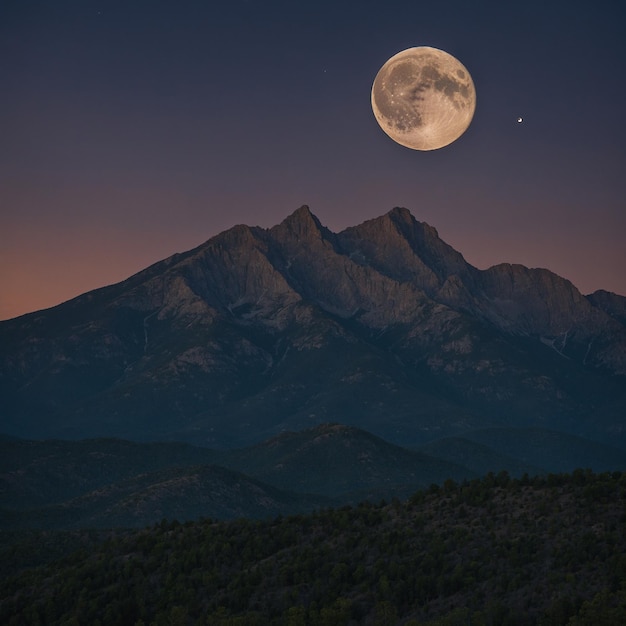 Photo a full moon is seen in the sky above a mountain