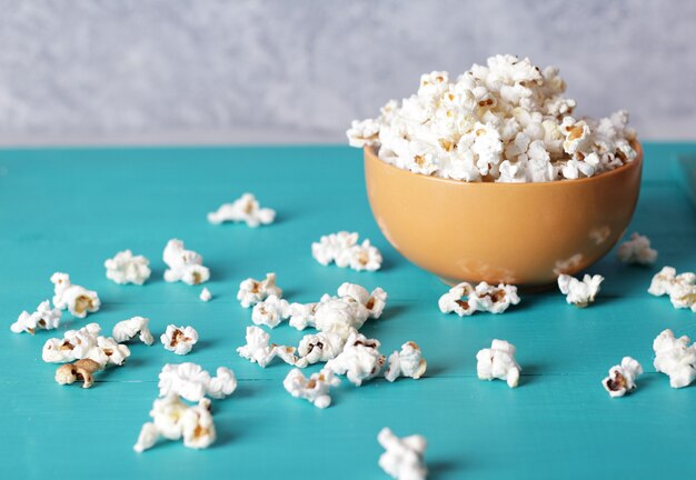 Full plate of popcorn, movie concept, close up of popcorn in bowl of salted popcorn at the old wooden table.