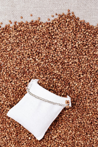 Full sack bag of buckwheat on background of cereal grains. Healthy food. Natural organic grain. Rich harvest.