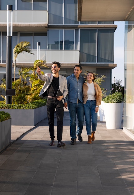 Full shot couple talking to real estate agent