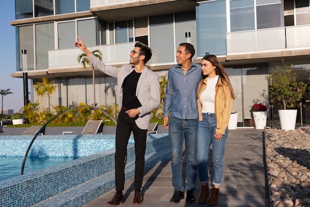 Full shot couple talking to real estate agent