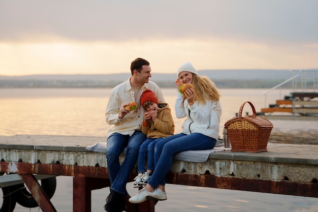 Full shot family hanging out on a jetty