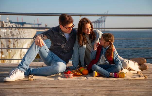 Photo full shot family hanging out on a jetty