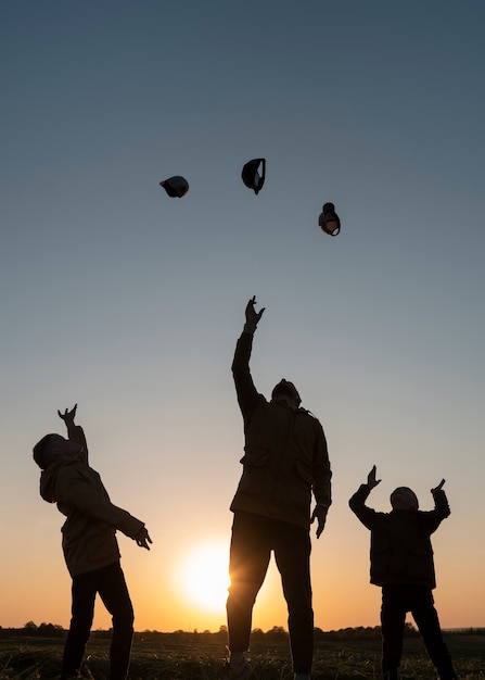 Full shot family silhouette having fun at sunset