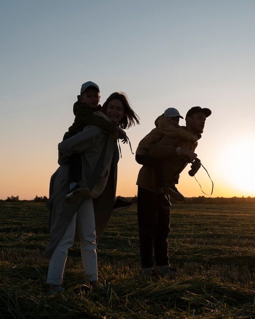 Full shot family silhouette having fun at sunset