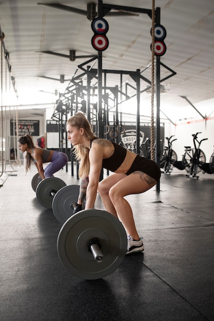 Full shot fit women training with barbells