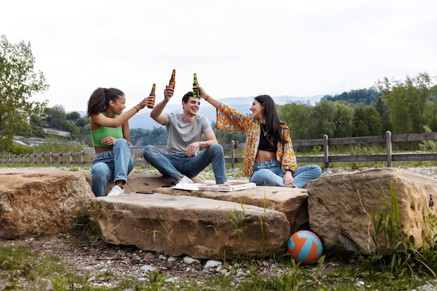 Full shot friends relaxing outside