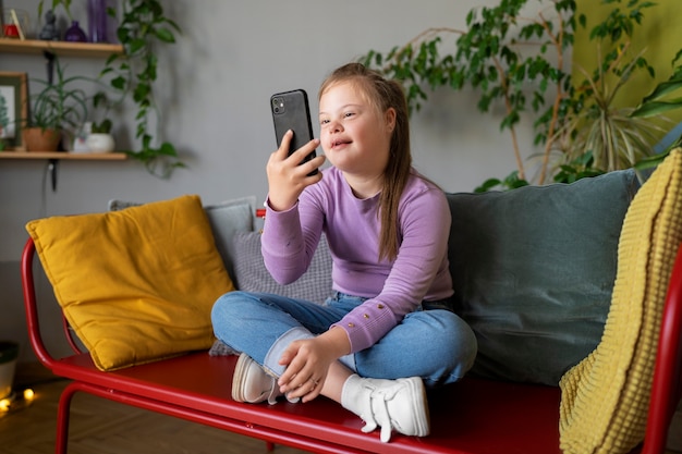 Full shot girl holding smartphone