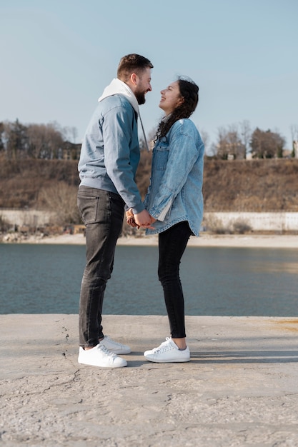 Full shot happy couple holding hands