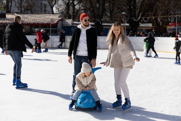 Full shot happy family having fun at rink