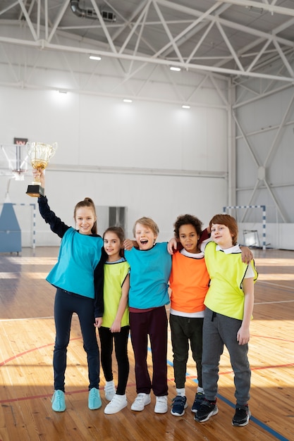 Full shot happy kids with golden cup