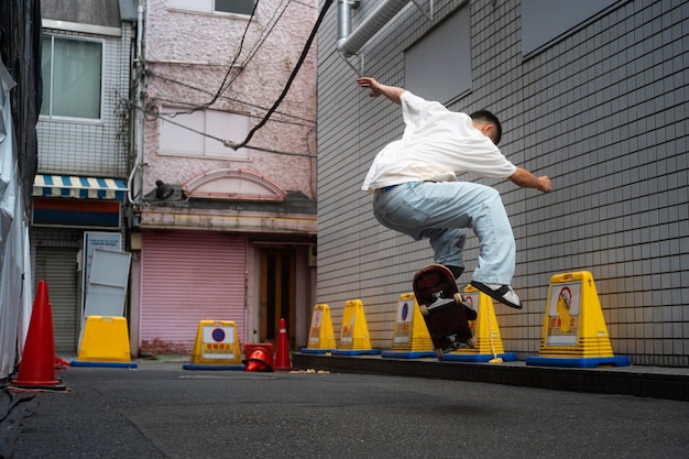 Full shot japanese man doing tricks on skateboard