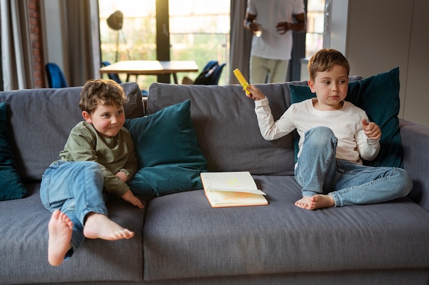 Full shot kids sitting on couch