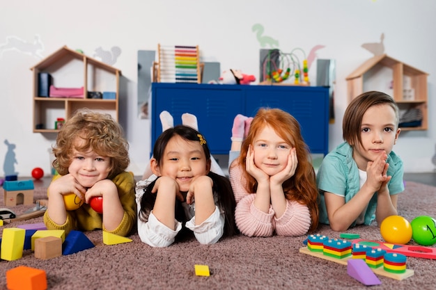 Full shot kids sitting together at kindergarten