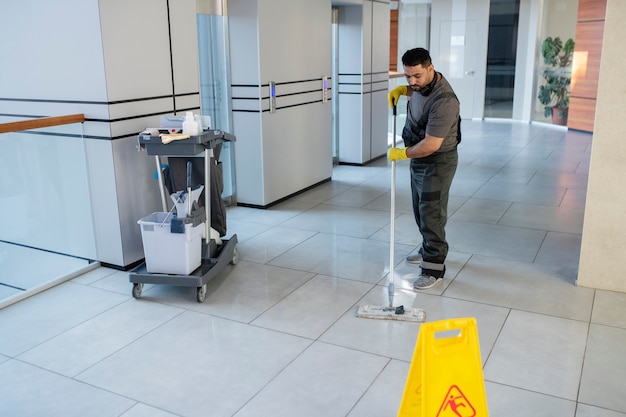 Full shot man cleaning office floor