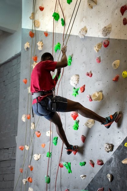 Full shot man climbing wall