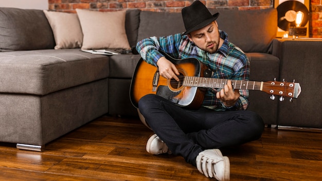 Full shot man playing the guitar