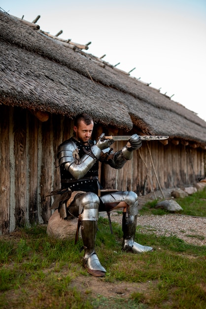 Full shot man posing as a medieval soldier