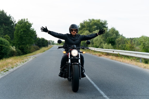 Full shot man with motorbike outdoors