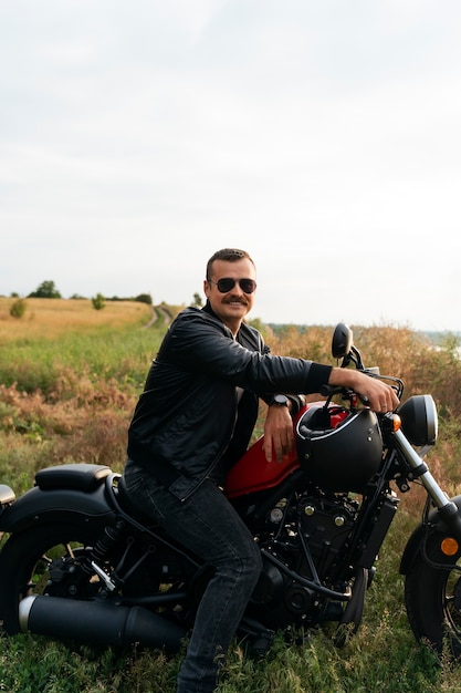 Full shot man with motorbike outdoors