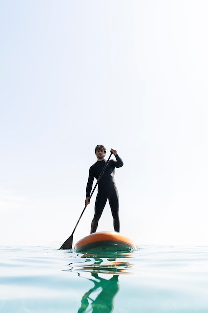 Full shot man with suit holding paddle