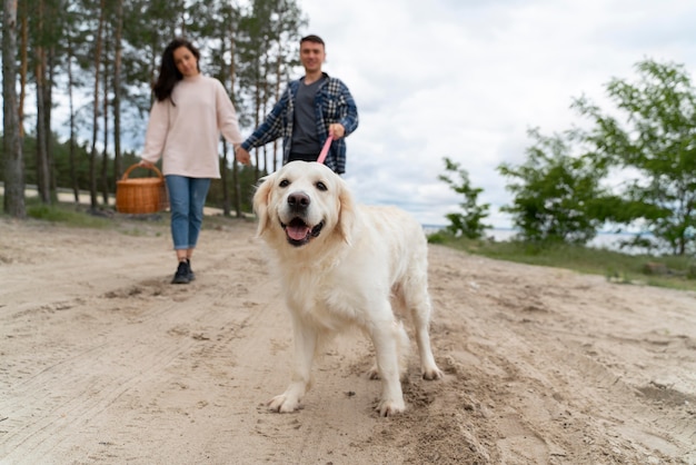 Full shot people walking with dog outdoors