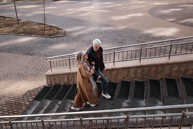 Full shot senior couple walking up stairs