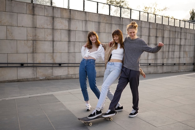 Full shot smiley people on skateboard outdoors