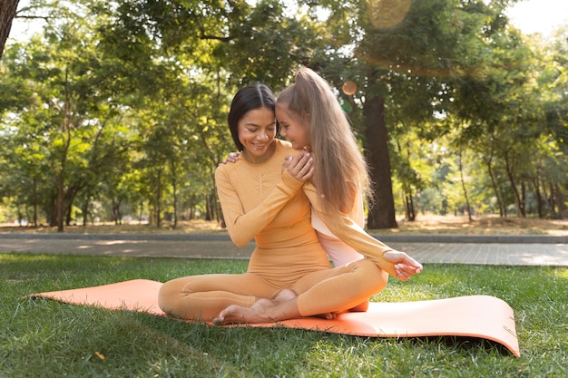 Full shot smiley woman and girl outside