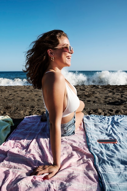 Full shot smiley woman laying on beach