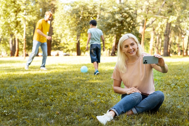 Full shot smiley woman taking selfie