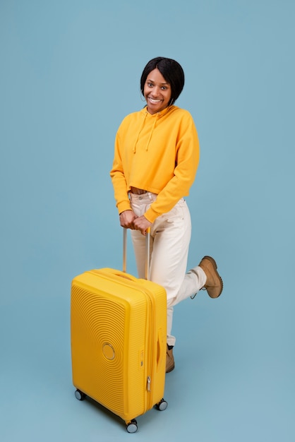 Full shot smiley woman with yellow baggage