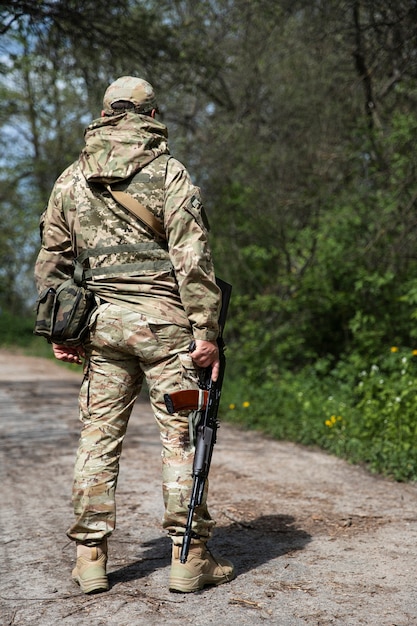 Full shot ukrainian soldier holding gun