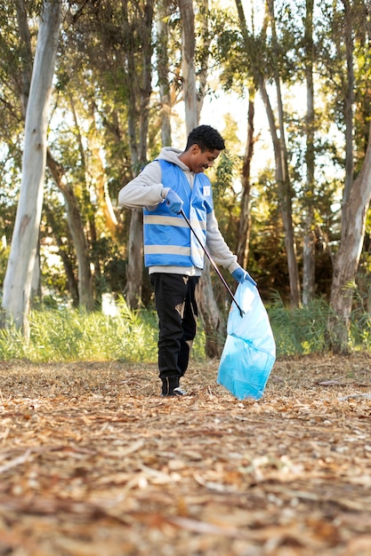 Full shot volunteer collecting garbage