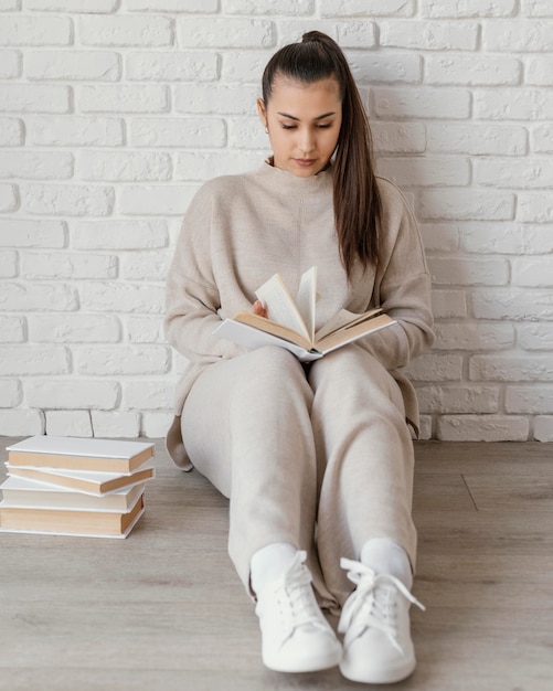 Full shot woman on floor reading