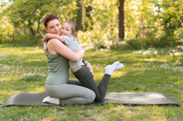 Full shot woman and girl hugging