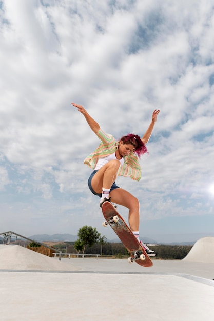 Full shot woman jumping on skateboard