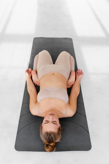 Full shot woman laying on mat