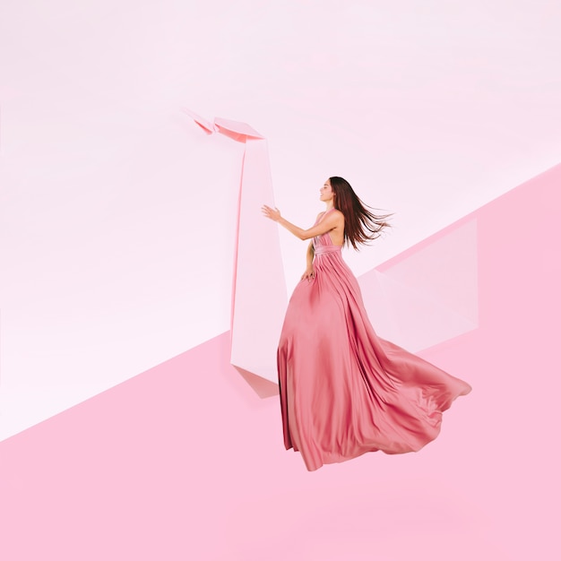 Full shot woman in pink dress levitating