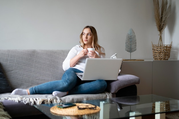 Full shot woman sitting on couch